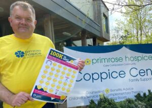 A man stood outside the Primrose Hospice Coppice building in a yellow primrose tshirt