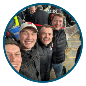 A group of men at a sporting event all smiling
