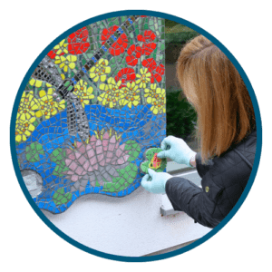 Jackie Mosaic artist installing the mosaic she has created at Primrose Hospice