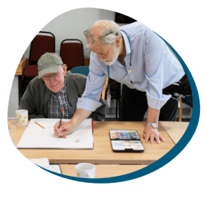 Paul one of our volunteers helping a patient in our art group.