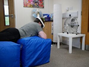 A teenage boy using virtual reality to experience a zipqire expereince at the Eden Project. 