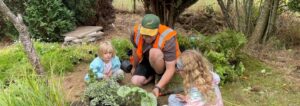 Two children and an adult gardening.